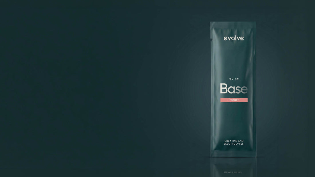 An evolve® Base sachet, creatine and electrolytes, standing upright on a deep green surface