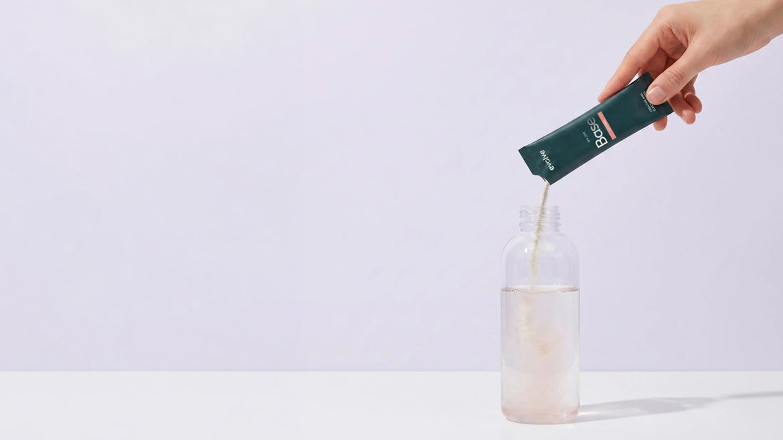 A Base sachet being poured into a bottle of water